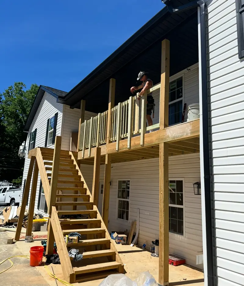 Barkley Apartment Project: crew installing railing on the second-story wood deck and stairs
