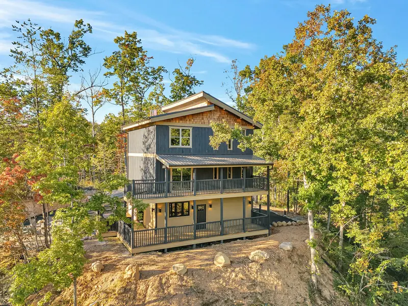 Cabin Project: two-story cabin with wraparound decks on a wooded hillside