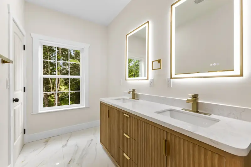 Hoppers Bluff spec home, Rutledge, TN: bathroom with dual sinks, wood cabinet, marble countertop and LED mirrors
