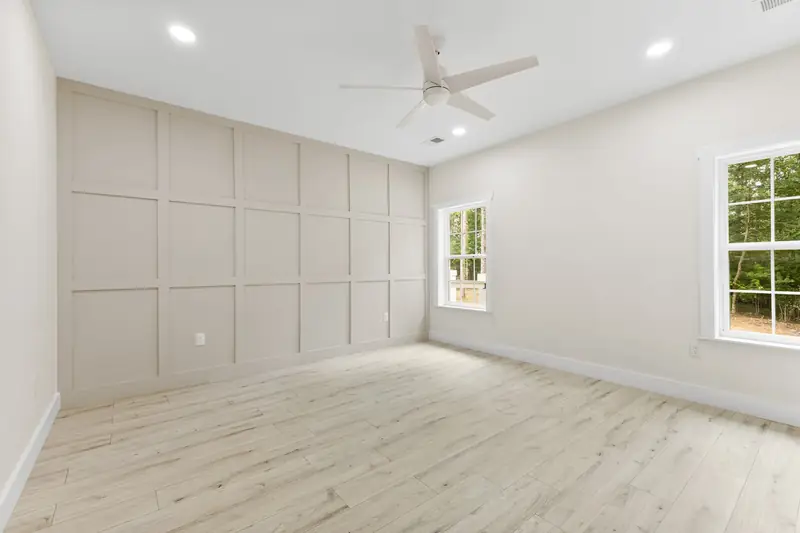 Hoppers Bluff spec home, Rutledge, TN: bedroom with light wood flooring, two windows and recessed lighting