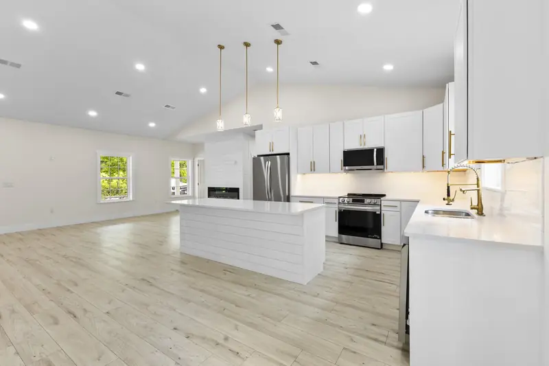 Hoppers Bluff spec home, Rutledge, TN: kitchen with white cabinets, black appliances, light wood flooring and gold fixtures