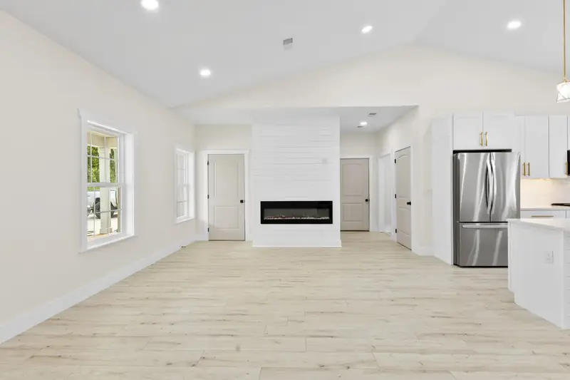 Hoppers Bluff spec home, Rutledge, TN: living room with a vaulted ceiling, recessed lighting and a modern fireplace wall