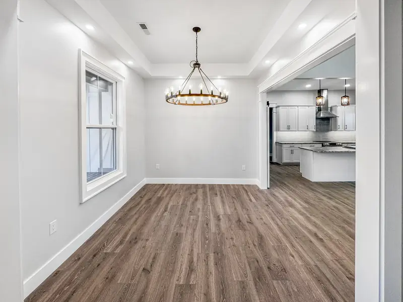 Shiloh Project: dining room with hardwood floors and a chandelier, opening to the kitchen